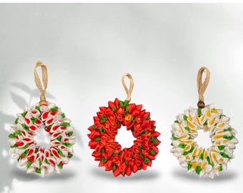 May include: Three colorful Christmas ornaments made of ribbon. The ornaments are wreath-shaped, with red, white, green, and yellow ribbons. Each ornament has a jute loop for hanging. Text reads "Christmas ornaments" and "Plumeria ribbon wreaths."