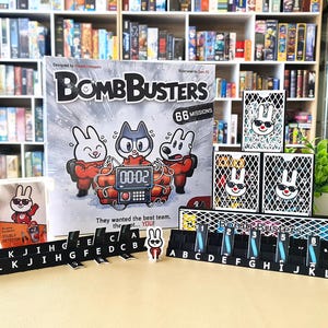 以下が含まれることがあります： 「BombBusters」というボードゲーム。箱には漫画のキャラクターが描かれています。ゲームにはカード、文字タイル、タイマーが含まれています。箱には「66 Missions」と「They wanted the best team... YOU!」と書かれています。