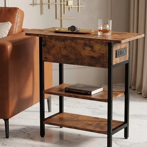 May include: A brown and black side table with two shelves and a top surface. The table has a rustic wood grain finish and a black metal frame. A watch, tray, and glass are on top. The table has a built-in power outlet.