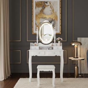May include: A white vanity table with an oval, illuminated mirror. The table has two drawers and a matching stool. The room features a gold-framed artwork and a side table with a lamp. The overall aesthetic is elegant and classic.