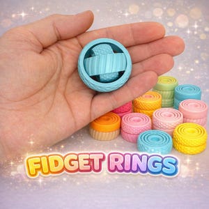 May include: A light blue fidget ring is held in a hand, with a collection of colourful fidget rings in the background. The text "FIDGET RINGS" is displayed in a colourful font.