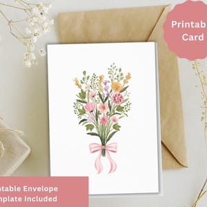Può includere: Una scheda stampabile bianca con un bouquet ad acquerello di fiori rosa, gialli e viola legato con un nastro rosa. La scheda è appoggiata su una busta marrone. Il testo sulla scheda recita "Printable Card" e "Printable Envelope Template Included".
