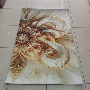 May include: Rectangular rug with a floral design in shades of brown, gold, and cream. The pattern features a central flower with swirling petals and decorative details. The rug is placed on a tiled floor.