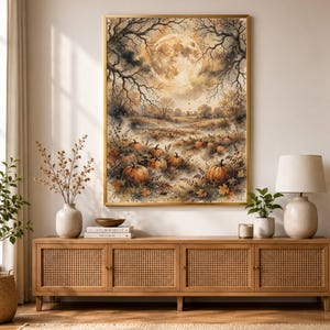 May include: A rectangular wall art print in a gold frame depicting a moonlit autumn landscape with bare trees, a large full moon, and a field filled with orange pumpkins, dry leaves, and misty ground, rendered in a warm, muted color palette.
