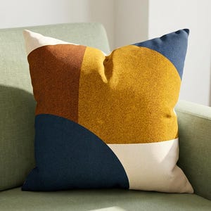 May include: A white ceramic mug with a black handle and the text "But First, Coffee" in a bold, black font. The mug is set against a blurred background, suggesting a cozy setting. The mug appears to be approximately 4 inches tall.