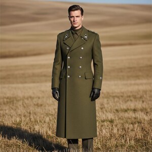 May include: An olive green double-breasted coat with silver buttons. The coat has a long, tailored fit and is worn with black gloves. The background is a field of dry grass under a clear sky.