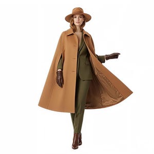 Puede incluir: Un abrigo tipo capa de color marrón claro con un sombrero a juego y guantes de cuero marrón. El abrigo está abotonado y tiene un forro marrón claro en contraste. El conjunto incluye un traje verde y botas de cuero marrón. El estilo general es clásico y elegante.