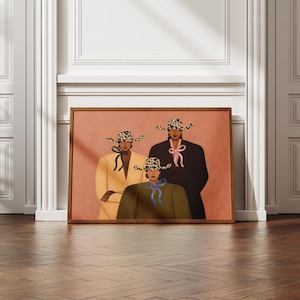 May include: A framed wall art print featuring three figures wearing leopard print hats with ribbons. The figures are dressed in a yellow blazer, a dark brown blazer, and a dark green top, set against a solid, muted terracotta background.