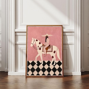 Pode incluir: Uma impressão de arte emoldurada apresentando uma pessoa usando um chapéu de abas largas e roupas listradas, montando um cavalo branco com manchas marrons. O fundo é de cor rosa sólida e o primeiro plano apresenta um padrão de xadrez.