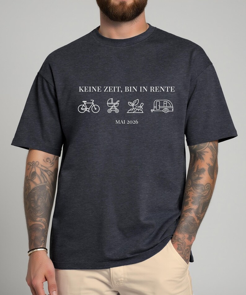May include: Dark gray t-shirt with white text and line drawings. The text reads "KEINE ZEIT, BIN IN RENTE" above a bicycle, stroller, plant, and camper icon, with "MAI 2026" below. The shirt is a casual style.
