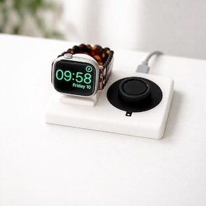 May include: A white charging station with a black circular charging pad and a silver smartwatch with a brown and black band. The watch displays the time as 09:58 on a black screen.