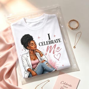 May include: A white t-shirt in a clear plastic bag featuring a graphic of a person with dark hair in a bun, wearing a white blazer, pink top, and ripped jeans. The text reads I CELEBRATE Me. Includes a gold bracelet, two necklaces, and a card that says Celebrate Your Power.