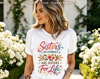 May include: A white short-sleeved t-shirt featuring a colorful graphic print that reads Sisters IN CHRIST ARE SISTERS For Life, accented with floral illustrations, small hearts, and decorative swirls, paired with light blue distressed denim jeans.