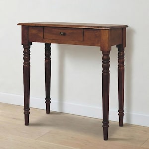 Könnte beinhalten: Braune Holzkonsolentisch mit einer Schublade und gedrechselten Beinen. Der Tisch hat ein klassisches Design. Er ist ca. 76 cm lang, 30 cm breit und 76 cm hoch. Das Holz hat einen warmen Farbton.