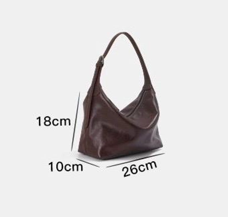 May include: A brown shoulder bag with a single strap. The bag is 10.2 inches long, 7.1 inches high, and 3.9 inches wide. The bag has a simple, minimalist design.