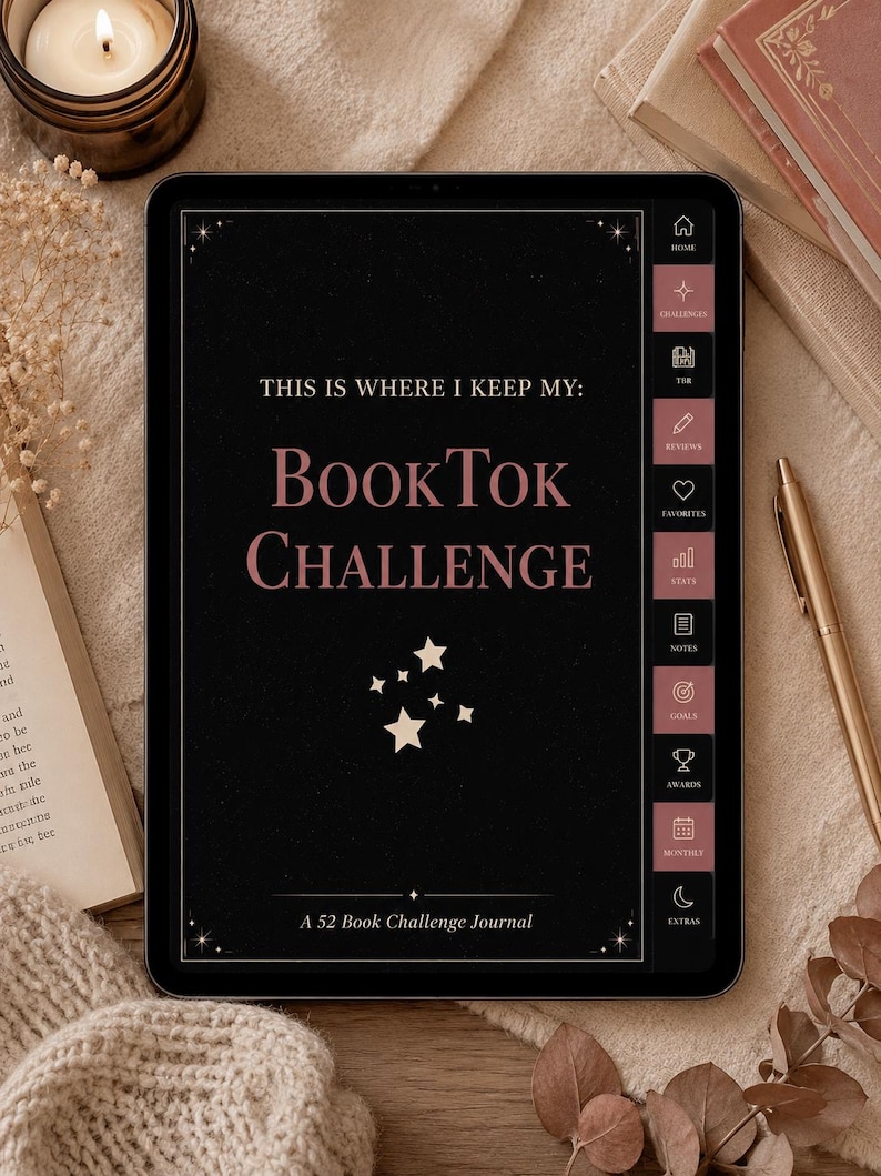 May include: A black tablet displaying a "BookTok Challenge" journal interface. The screen features text and icons in white and pink, with a decorative border. The tablet is on a beige surface, with a candle, pen, and books in the background.