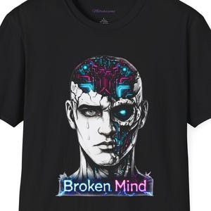 May include: Black t-shirt featuring a graphic of a human face, half organic and half robotic, with the text "Broken Mind" in a neon-style font. The design incorporates blue, purple, and white colors, creating a futuristic aesthetic. The shirt is a classic crew neck.