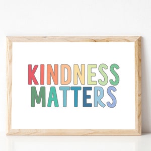 May include: A framed print with the text "KINDNESS MATTERS" in rainbow colors. The letters are outlined in black and have a slightly rounded font.