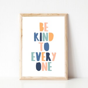 May include: A framed print with the text "BE KIND TO EVERY ONE" in colorful, block letters. The letters are in shades of blue, green, orange, and pink.