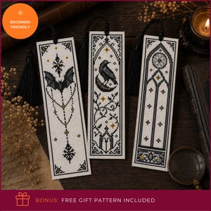 May include: Three rectangular cross-stitch bookmarks on white fabric with black and gold thread designs. The left features a bat, the center a raven on a crescent moon, and the right a gothic arch. Each has a black tassel attached at the top.