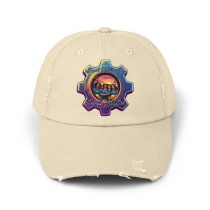 May include: A distressed beige baseball cap featuring a colorful gear-shaped graphic. The graphic includes the text "Welcome STEM Friends" and "Strength & Stilettos" with an image of three people. The cap has a curved brim and a worn appearance.