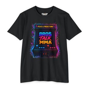 May include: A black short-sleeve t-shirt featuring a colorful graphic of a retro arcade cabinet. The screen displays the text BRO$ TALK MMA in blue, red, and orange, with PICKS & PREDICTIONS above. The design includes vibrant paint splatter effects.