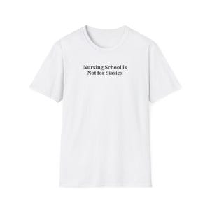 May include: White t-shirt with the text "Nursing School is Not for Sissies" in black, centered on the front. The shirt has short sleeves and a crew neck. The background is plain white.