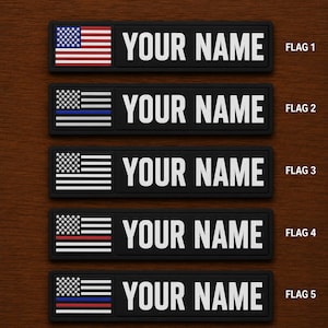 May include: Five black rectangular patches with white text reading "YOUR NAME". Each patch features a different American flag design. The flags include the standard US flag, a blue line, and a red line.