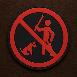 May include: A round, black and red sign with a graphic of a person with a raised stick and a dog, both inside a red circle with a red slash. The sign is on a dark wood surface.