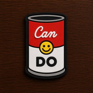 May include: A rectangular patch featuring a stylized soup can design with a red top half and white bottom half. The word Can is written in white script, a yellow smiley face is in the center, and the word DO is printed in black block letters.