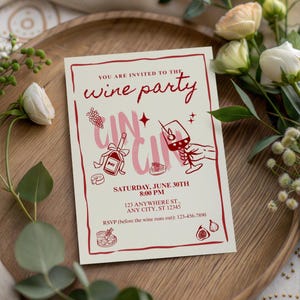 Op de afbeelding: Een uitnodiging voor een wijnfeest met een cr&egrave;mekleurige achtergrond en rode tekst en illustraties. De tekst luidt "YOU ARE INVITED TO THE wine party" en bevat de datum, tijd en RSVP-informatie. De uitnodiging ligt op een houten dienblad met bloemen.