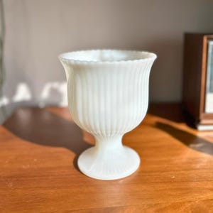 May include: A set of three ceramic mugs with a speckled, matte finish. The mugs are in shades of cream, light gray, and dark gray. Each mug has a simple, minimalist design, perfect for coffee or tea.