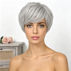 May include: A short, layered, silver-gray wig with a side-swept bang. The wig has a natural-looking hairline and is styled to frame the face. The image is a close-up, showing the texture and color of the wig.