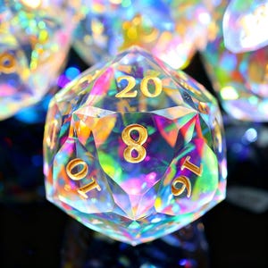 May include: A clear, twenty-sided die with gold numerals. The die reflects a rainbow of colours, including pink, green, and yellow. The number 20 and the number 8 are visible on the die's faces. Other dice are visible in the background.