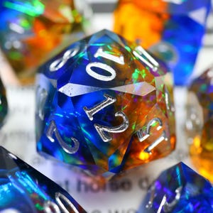 May include: A white ceramic mug with a black handle and the text "But First, Coffee" in a bold, black font. The mug is sitting on a wooden surface. The mug is approximately 4 inches tall.