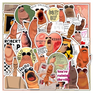 May include: A collection of colorful stickers featuring cartoonish, worm-like characters with various expressions and text. Some stickers include phrases like "Robert Help," "Kiss?" and "You're ruining the vibe."