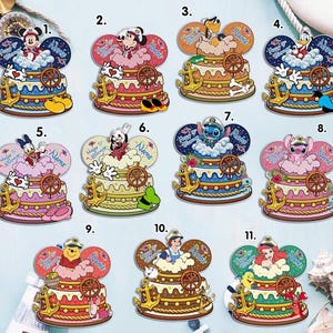 May include: A collection of colorful, cartoon-style cake decorations featuring various Disney characters. Each decoration is shaped like a cake with a character on top, a ship's wheel, and an anchor. The cakes have a nautical theme and include the text "Happy 5th Birthday" and "Name".