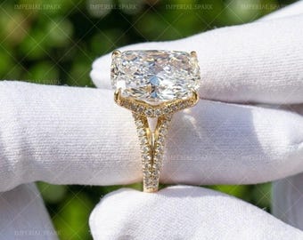 May include: A gold ring featuring a large, rectangular cushion-cut center stone with a faceted surface. The band and the setting are encrusted with small, round pavé-set stones, creating a continuous sparkling effect along the metal structure.