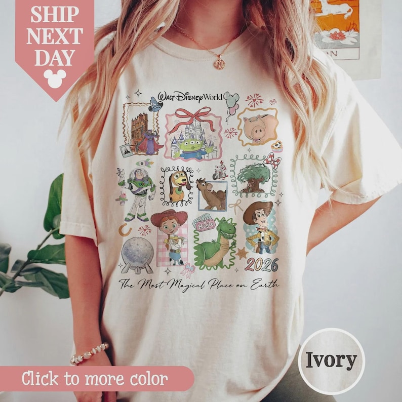 Puede incluir: Camiseta de color marfil con un gr&aacute;fico colorido de personajes de Disney y el texto "Walt Disney World" y "2026". La camiseta tambi&eacute;n incluye la frase "The Most Magical Place on Earth".