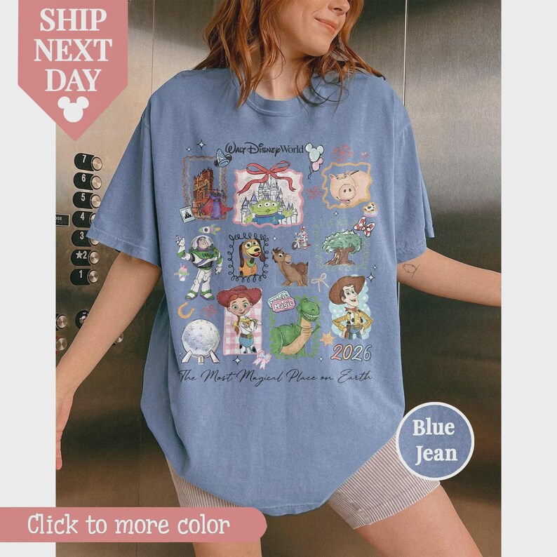 Puede incluir: Camiseta azul vaquero con un gr&aacute;fico colorido de personajes de Disney y el texto "Our Disney World 2026". La camiseta tambi&eacute;n tiene el texto "The Most Magical Place on Earth".