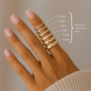Op de afbeelding: Een serie van zes gouden stapelringen in koepelvorm met variërende breedtes van 1,5 mm, 2 mm, 3 mm, 4 mm, 5 mm en 6 mm. De ringen zijn verticaal gestapeld en hebben elk een gladde, gepolijste afwerking en een afgerond profiel.
