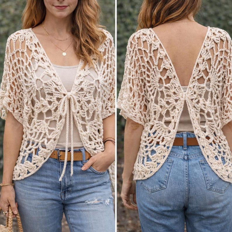 May include: Cream-colored, open-front crochet cardigan with short sleeves. The cardigan features a delicate, openwork design and a tie closure at the front. The back of the cardigan has a V-shaped opening. The cardigan is paired with blue jeans.