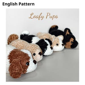 May include: Five plush crochet puppy toys arranged in a row, featuring various color patterns including brown and white, tan, black and white, cream, and black and tan. The text "English Pattern" and "Loafy Pups" appears above the toys.