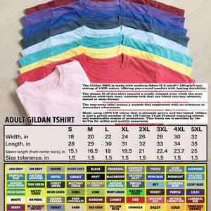 May include: A stack of Gildan 5000 adult t-shirts in various colors, including red, blue, and yellow. The shirts have a classic fit and are made of 100% cotton. Size chart with measurements in inches is included.