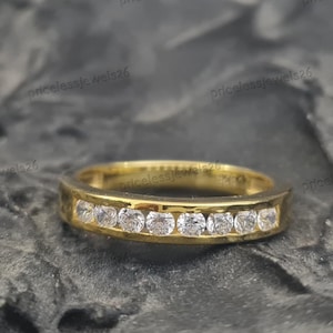 Alianza de boda de plata de ley 925 con diamantes simulados redondos engastados en canal y baño de oro amarillo de 14 quilates.