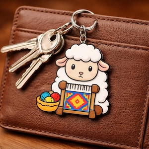 Peut inclure: Un porte-clés en forme de mouton avec un motif de tapis coloré, un panier de laine et un jeu de clés. Le porte-clés est attaché à un portefeuille en cuir marron. Le mouton a un corps blanc duveteux, des oreilles roses et un visage souriant.