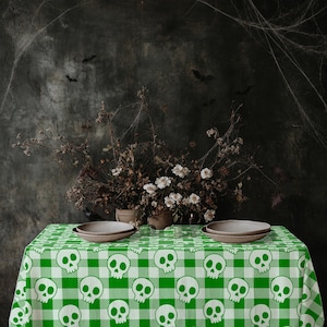 Peut inclure: Une nappe rectangulaire présentant un motif répétitif de crânes blancs imprimés sur un design à carreaux vichy vert et blanc. Le tissu recouvre une surface, offrant un élément visuel audacieux et contrasté pour les tables.