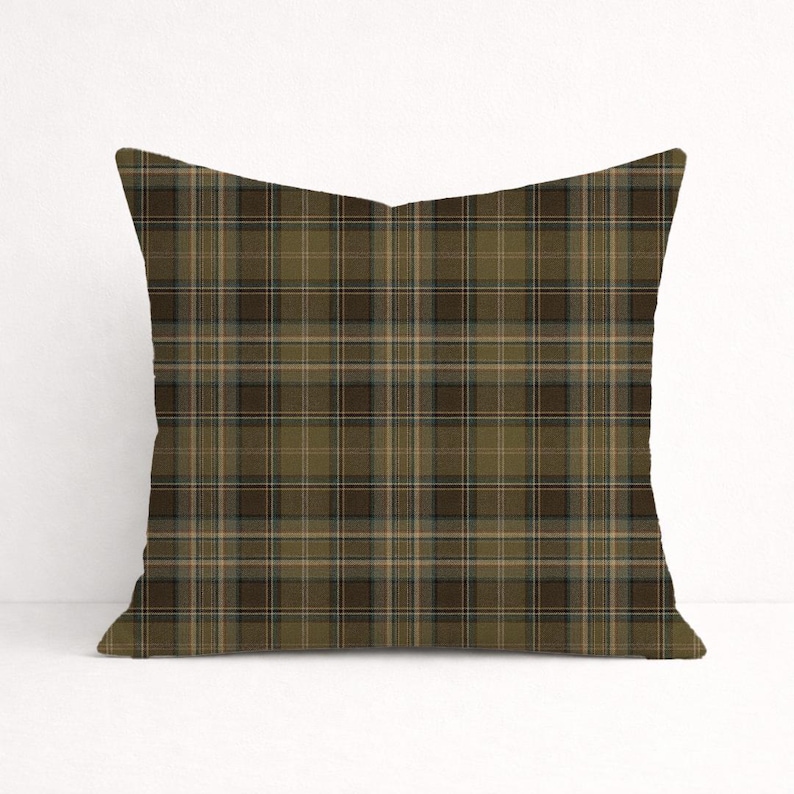 Puede incluir: Coj&iacute;n decorativo cuadrado con un estampado de cuadros en tonos verde oliva, marr&oacute;n y beige. El coj&iacute;n presenta un dise&ntilde;o tart&aacute;n cl&aacute;sico, adecuado para la decoraci&oacute;n del hogar. El coj&iacute;n tiene forma cuadrada.