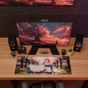 Może przedstawiać: Konfiguracja biurka komputerowego z dużym monitorem wyświetlającym czerwoną i różową scenerię krajobrazu. Klawiatura, mysz i podkładka pod mysz w stylu anime znajdują się przed monitorem. Głośniki, słuchawki i elementy dekoracyjne dopełniają konfigurację.