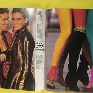 K&ouml;nnte beinhalten: Zwei Frauen tragen farbenfrohe Satinjacken. Die Frau links tr&auml;gt eine rot-schwarz gestreifte Jacke. Die Frau rechts tr&auml;gt eine goldene Satinjacke. Der Text "BIJOUX SATINS, GLITZ GALORE" ist im Bild sichtbar.